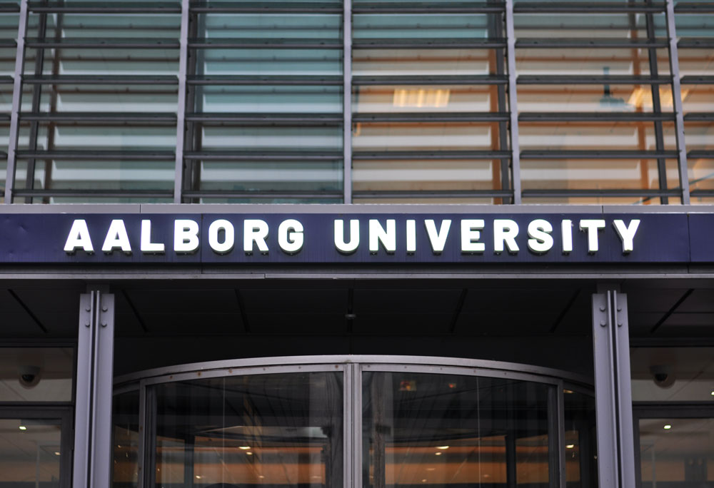 Lysskilt på facaden hos Aalborg universitet