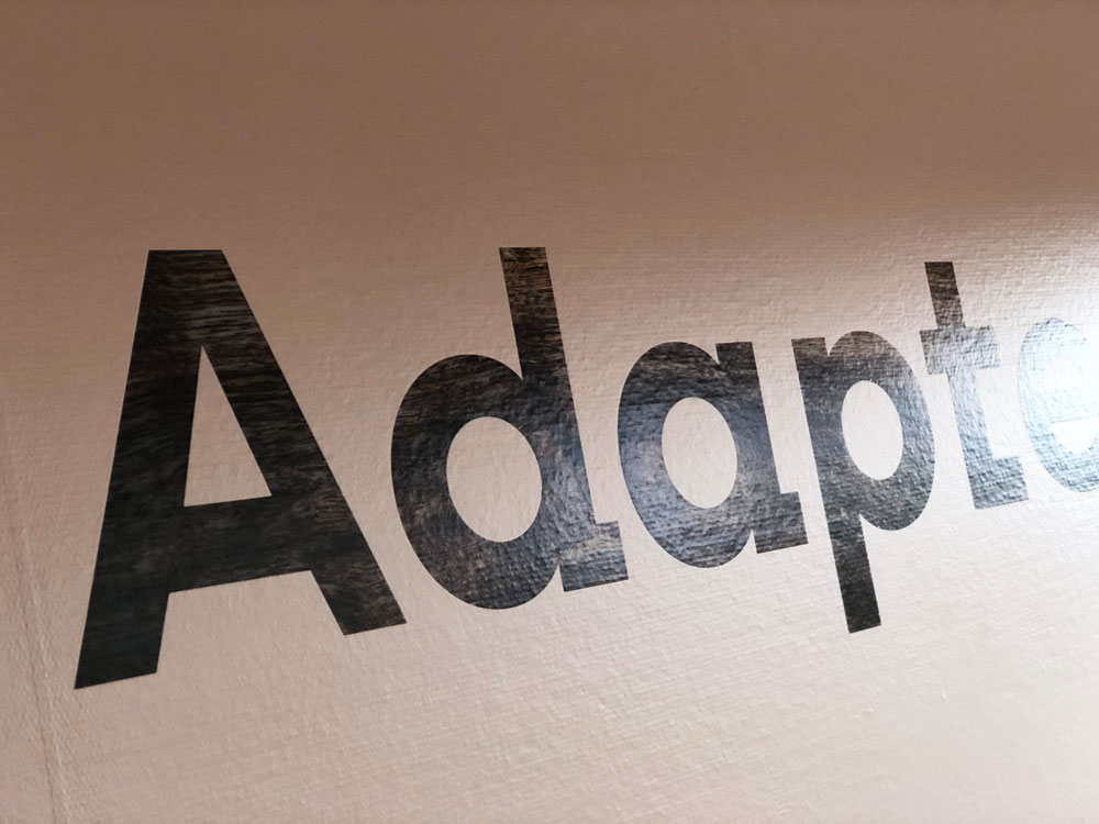 Logo på bagvæg hos Adapteo